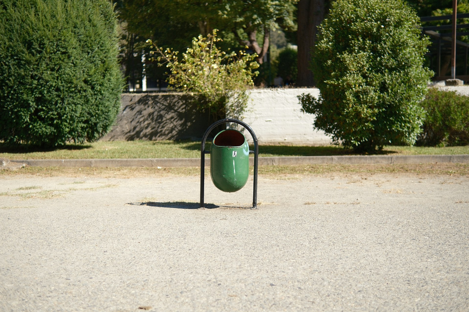 A trash can sitting in the middle of a parking lot